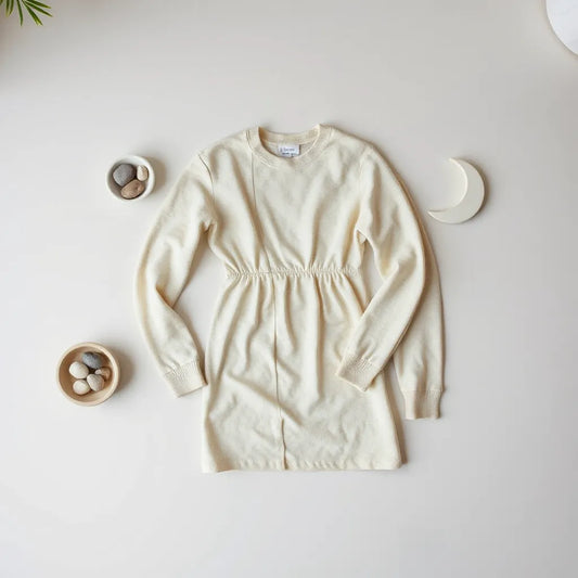 Neutrally styled moon-phase themed clothing with soft props on a clean flat-lay backdrop